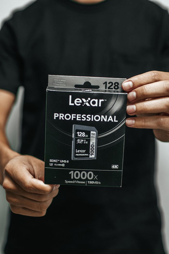 Close-up of a person holding a Lexar Professional 128GB memory card package.